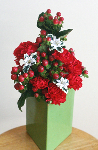 緑の花瓶と赤い花で、クリスマスツリーっぽく活ける